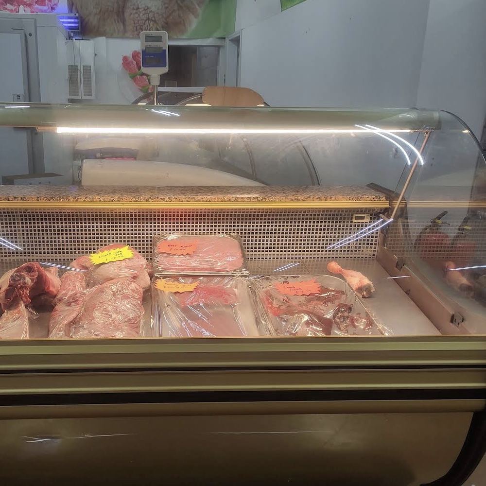The glass butcher's counter at Madina Store with fresh lamb and beef on display