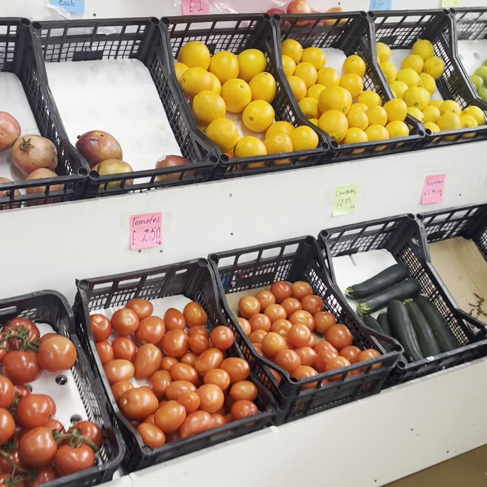 Crates of tomatoes, lemons, pomegranates and courgettes on the fruit and veg display at Madina Store